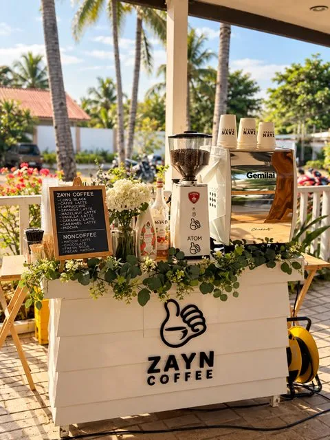 Zayn Coffee mobile coffee cart decorated with greenery and flowers in a covered outdoor area