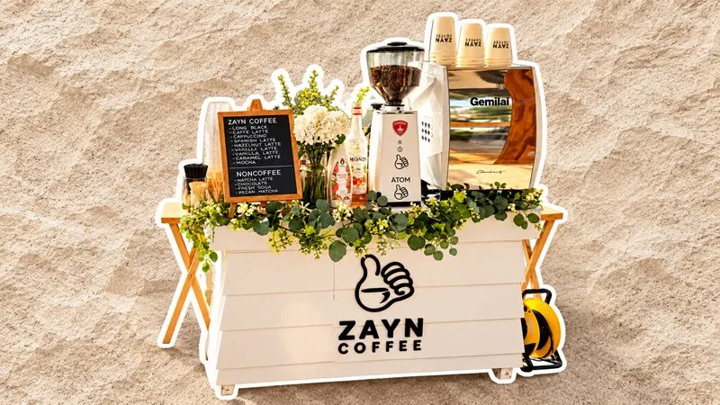 The Zayn Coffee mobile coffee cart with its espresso grinder, cups and greenery