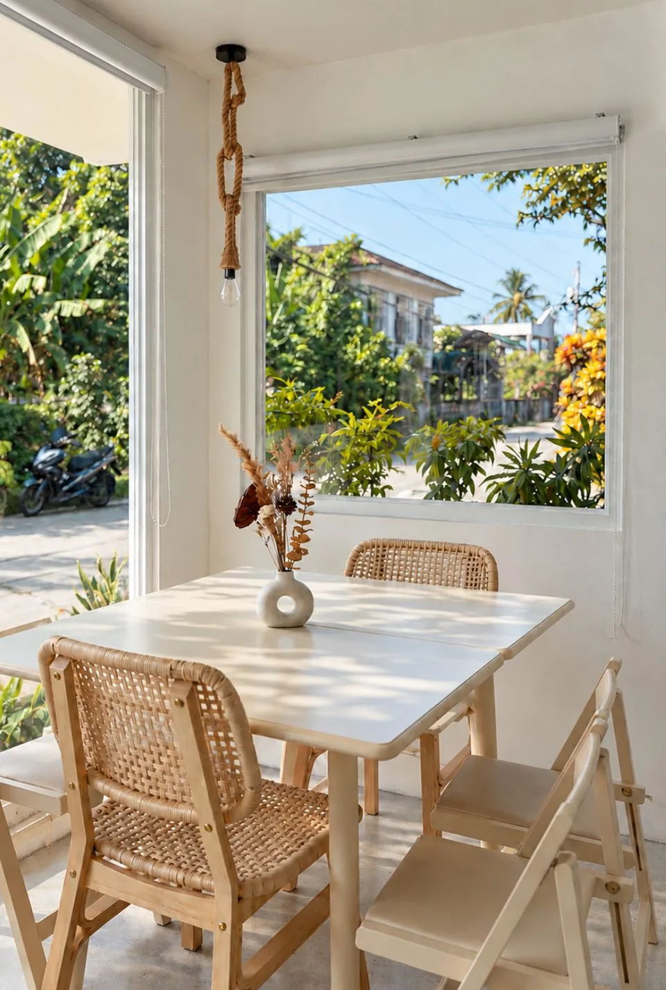 A sunny window table with rattan chairs and a garden view inside Zayn Coffee