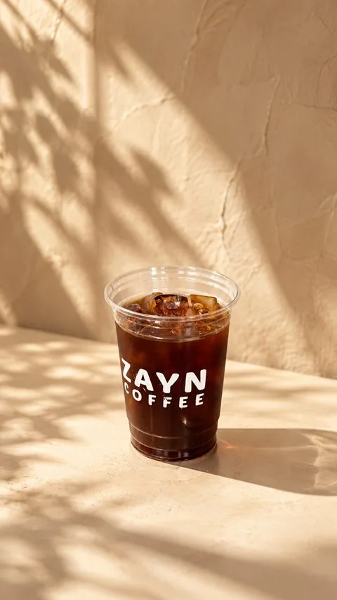 Cold Brew in a ZAYN COFFEE cup on a sunlit ledge