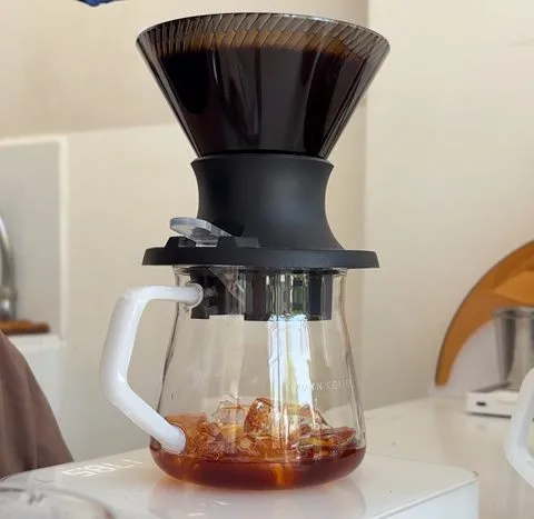 Iced Japanese pour-over brewing through a dripper onto ice at Zayn Coffee