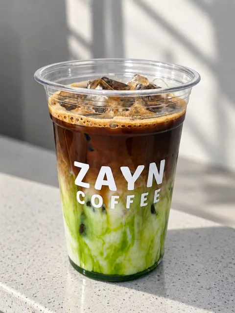 Iced Pandan Latte with espresso over green pandan milk in a ZAYN COFFEE cup