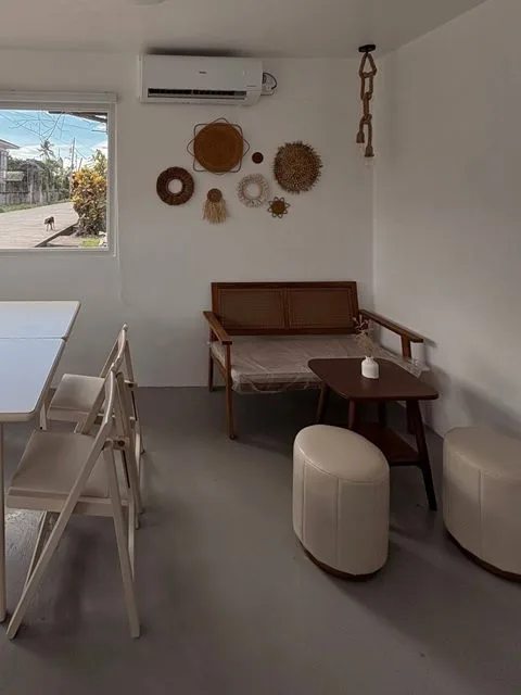 A wood and rattan bench, wooden side table and woven wall decor in the dining corner at Zayn Coffee