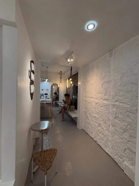 A textured cream wall and seating along a hallway inside Zayn Coffee